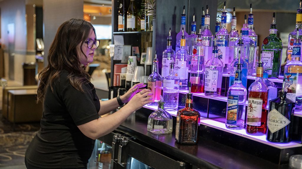 woman organizing bottles at a bar