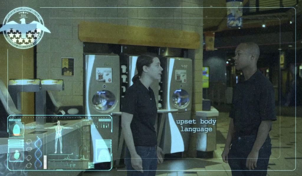 two employees standing facing each other in lobby environment with serious faces